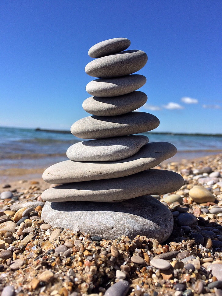 gray stacking stones near body of water