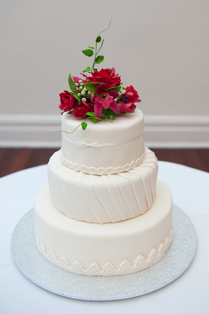 3-tier cake with pink petaled flowers on top