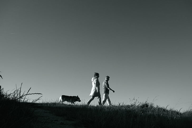 grayscale photography of man and woman walking