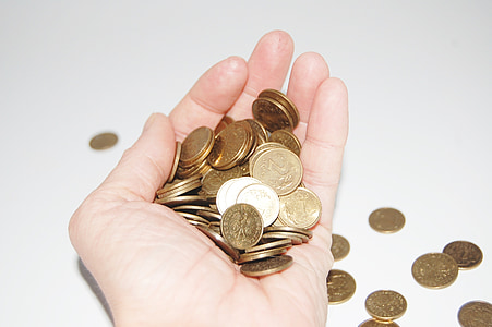 person holding round gold-colored coins