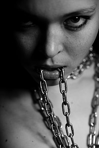 grayscale photo of woman biting chain