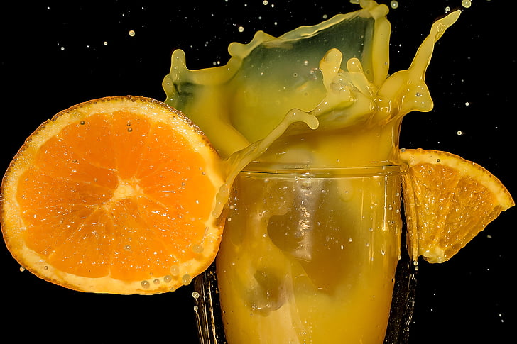 orange juice on clear drinking glass