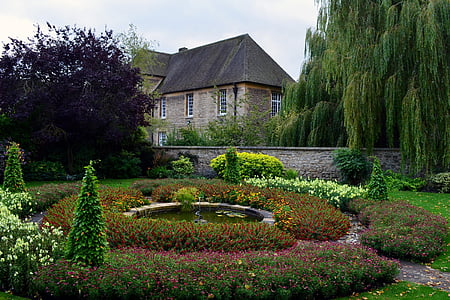 fountain surround by flowers near house