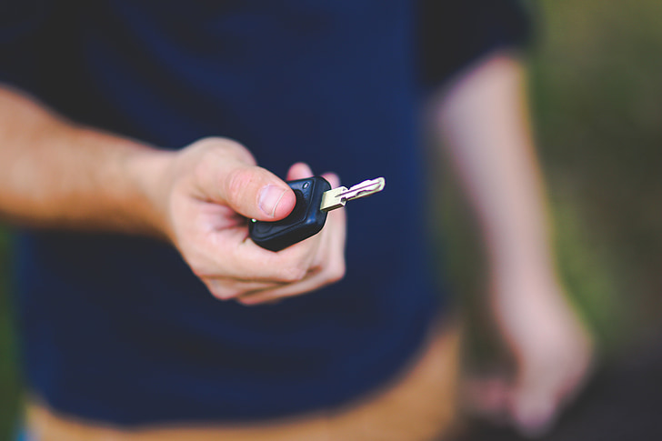 person holding black vehicle key