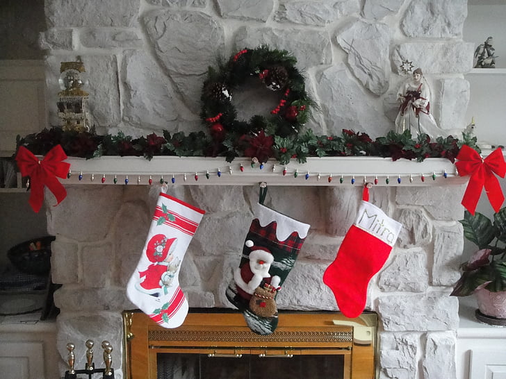 three Christmas socks hanging on fireplace
