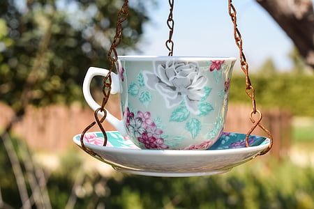shallow focus photo of hanging teacup and saucer