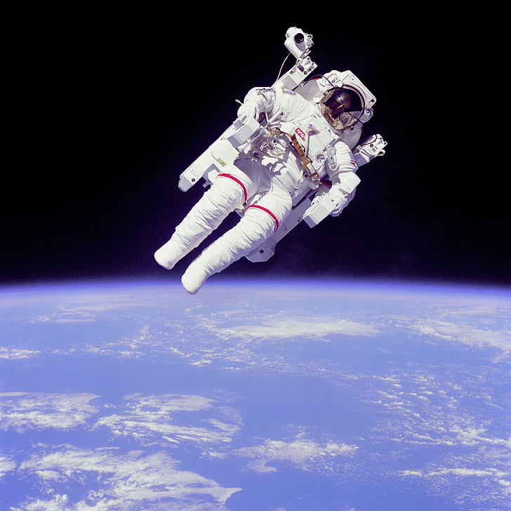 photo of astronaut floating above earth