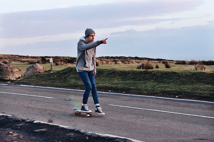 man riding skateboard in the middle of road