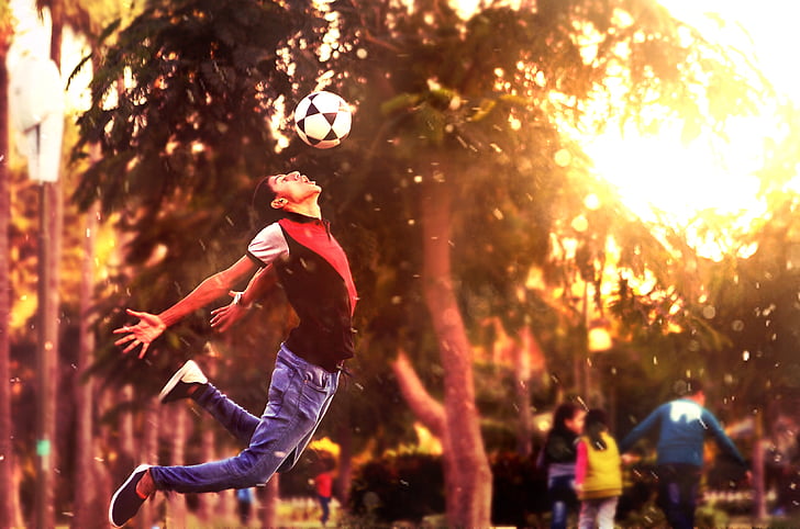 person playing soccer during sunset