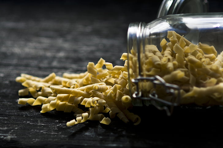 shallow focus of pasta spilling from jar