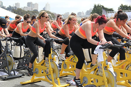 time lapse photography of women riding stationary bikes