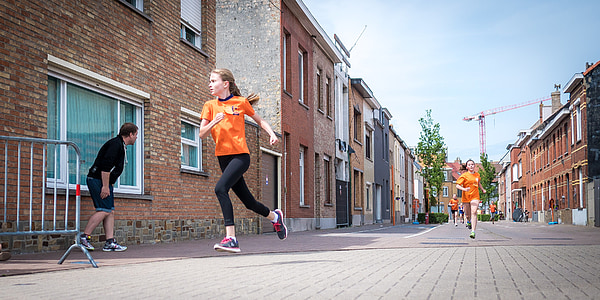 photo of women wearing orange t-shirt running on the streets