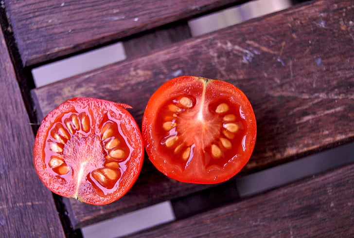 two slice tomato on brown wooden surface