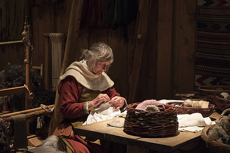 photo of woman stitching white textile