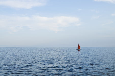 white and red sailboat on ocean