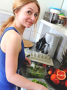 woman wearing blue tank top holding white plastic container