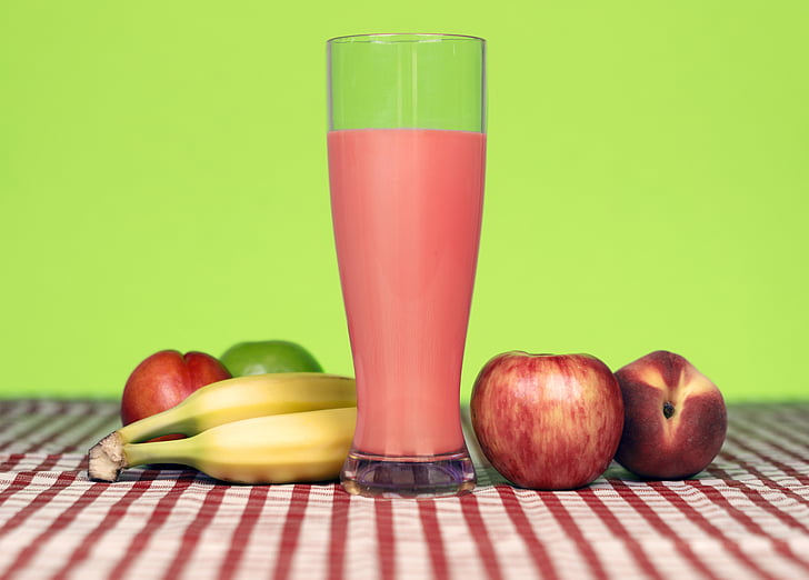 red apple near banana and clear glass cup