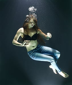 woman wearing black bra and blue jeans under water photography