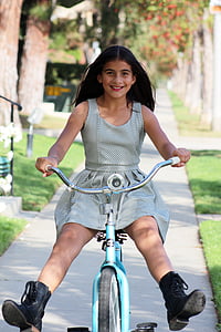 girl riding on bicycle on pathway