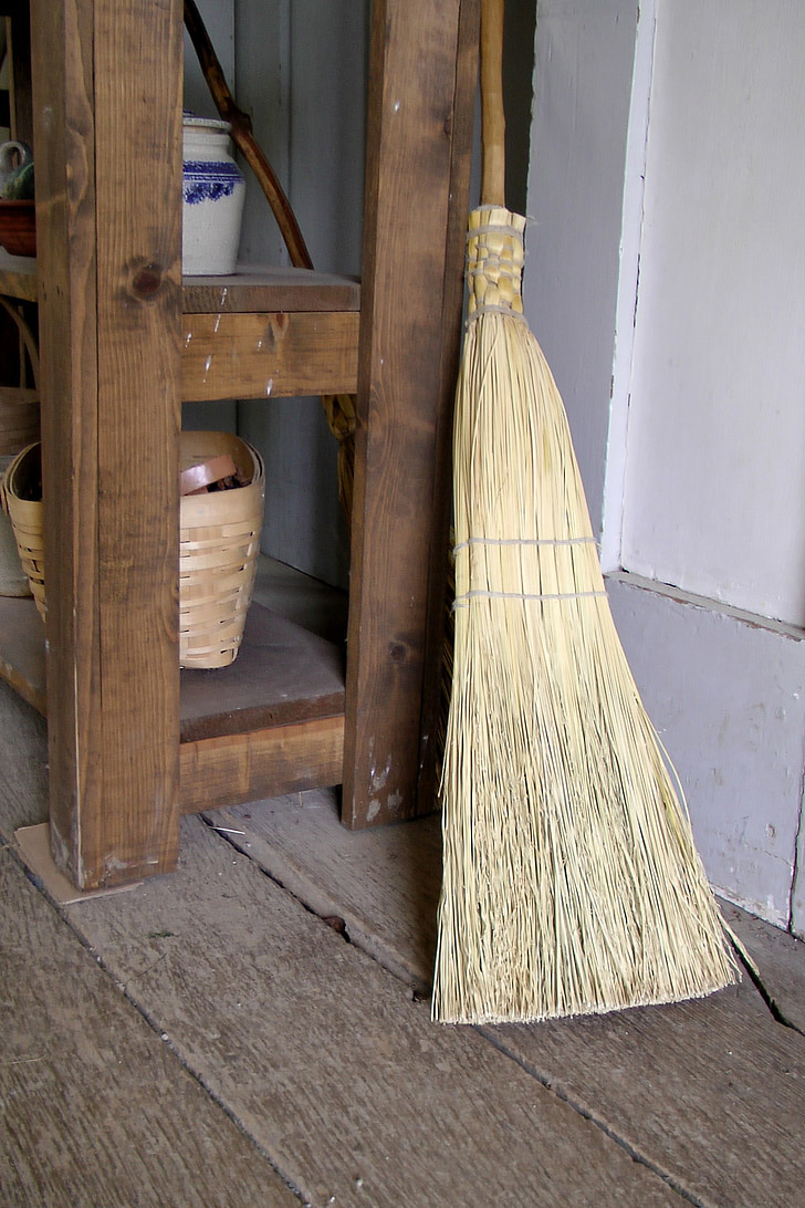 brown and beige broom leaning on table