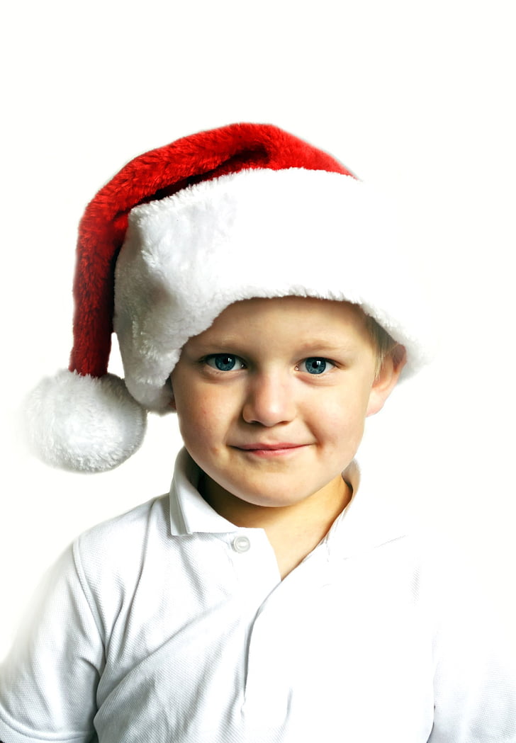 boy in white polo shirt and red Santa cap
