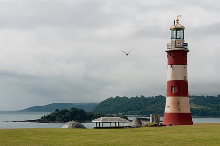 red and white lighthouse near body of water