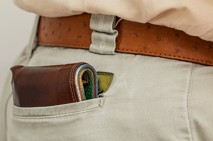 brown leather wallet in gray bottoms pocket