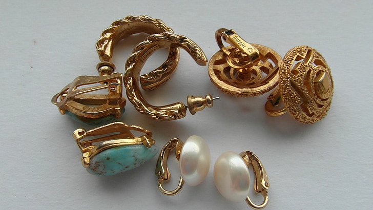 gold-colored jewelries on top of white surface