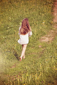 girl walking on flower field during daytime