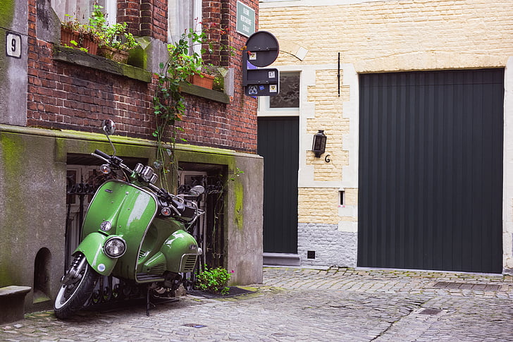green motor scooter on alleyway