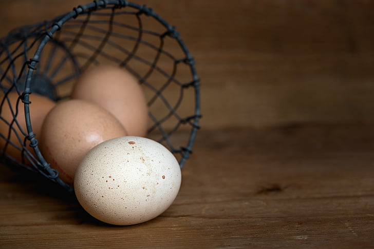 white and brown eggs in black wire basket