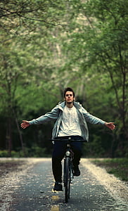 shallow focus photography of man riding on bicycle