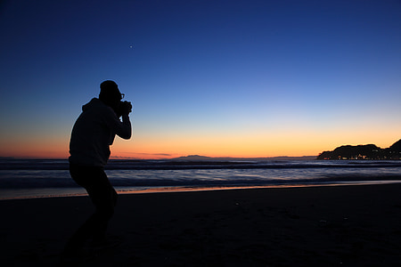silhouette of person standing near seashore