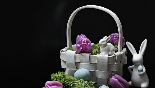 two white ceramic Easter bunnies with white wicker basket