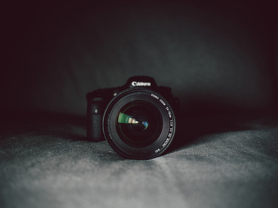 black Canon DSLR camera on black suede apparel