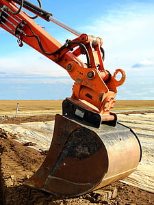 orange and brown heavy equipment under blue sky at daytime