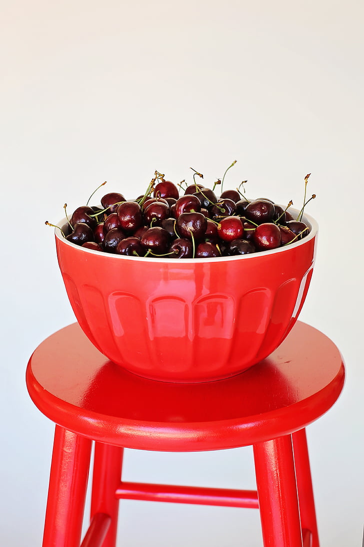round red fruit lot filled red bowl