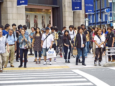 people standing facing pedestrian lane near building