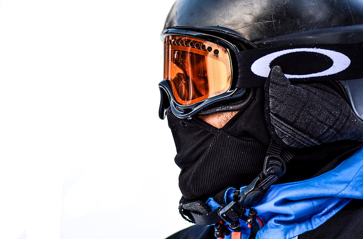 person wearing orange Oakley snow goggles with black frame