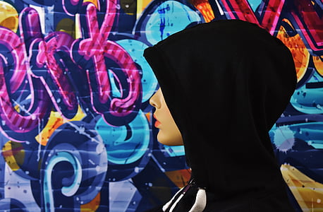 woman wearing black hijab headscarf beside wall painting