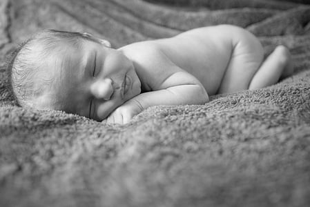baby sleeping in grayscale photo