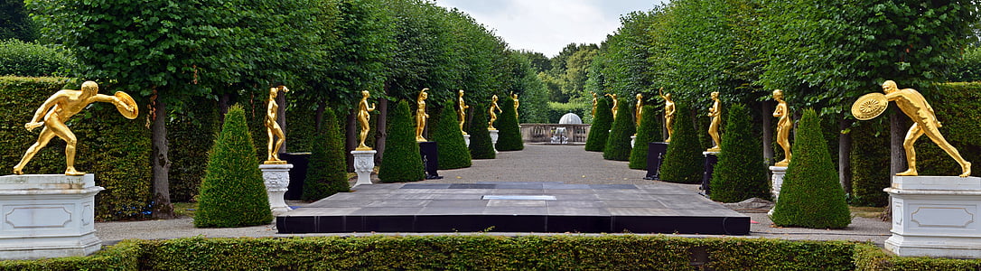 statues beside green trees during nighttime