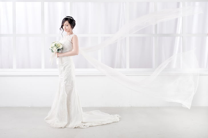 Royalty-Free photo: Woman standing wearing white wedding 