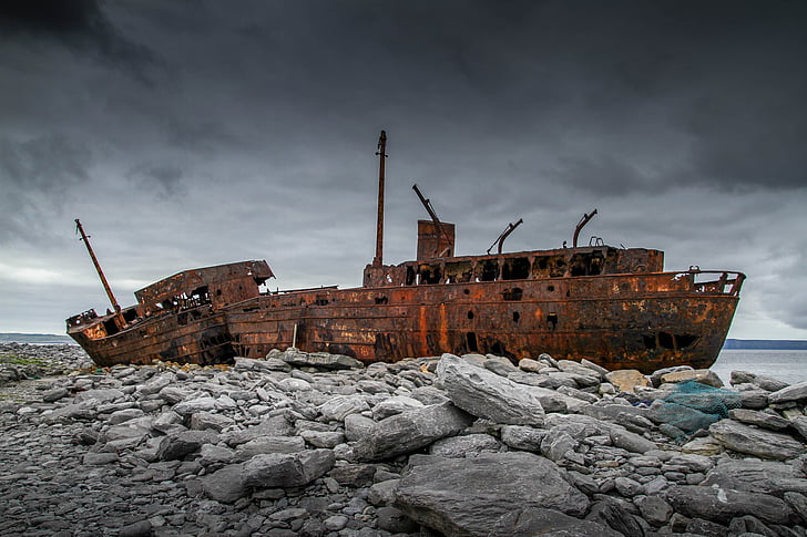 brown ship wreck on rocky shore