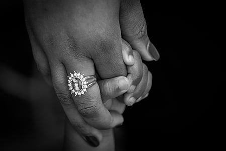 grayscale photography of adult holding toddler's hand