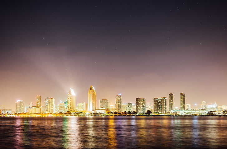 landscape photography of cityscape beside body of water at night