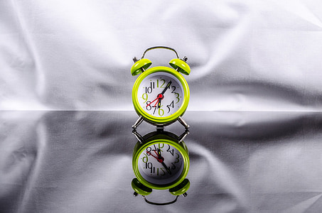 green and white analog alarm clock
