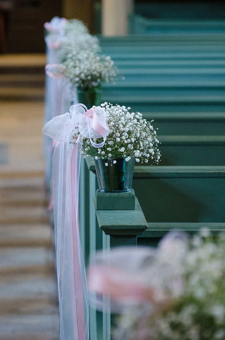 white baby's breath flowers in gray pot on top gray wooden pew
