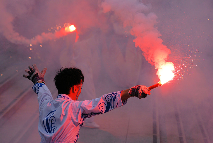 man waving flare sticks