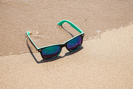 black framed Justin sunglasses on sand